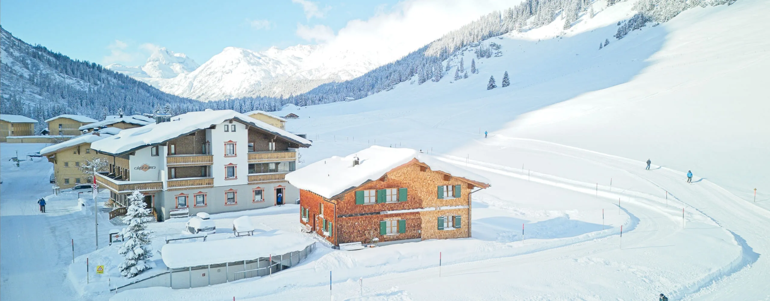 Blick auf schneebedeckte Berglandschaft mit Hütten.