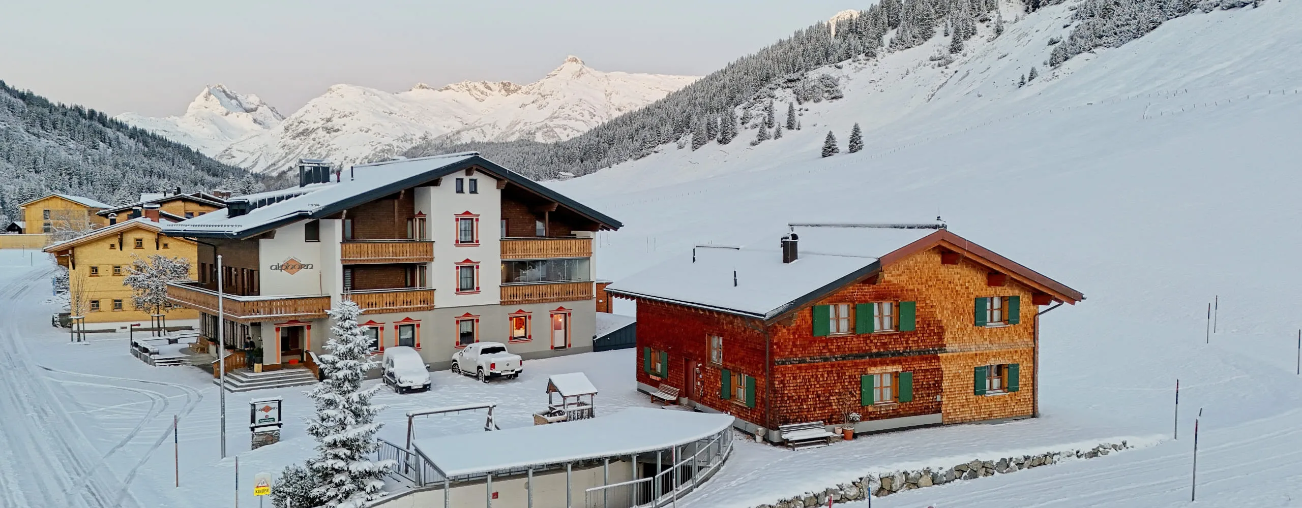 Winter view of Gasthof Alphorn with snow-covered mountains