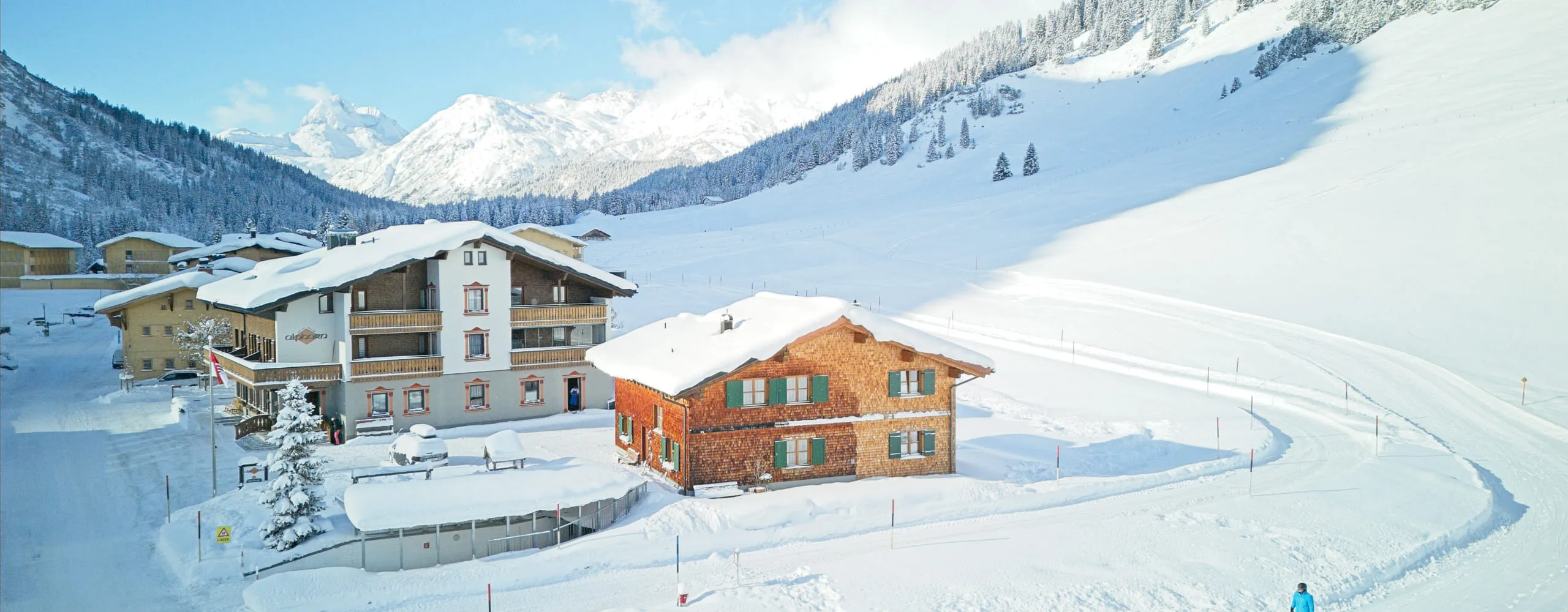 Berglandschaft mit verschneiten Hütten und Pisten.