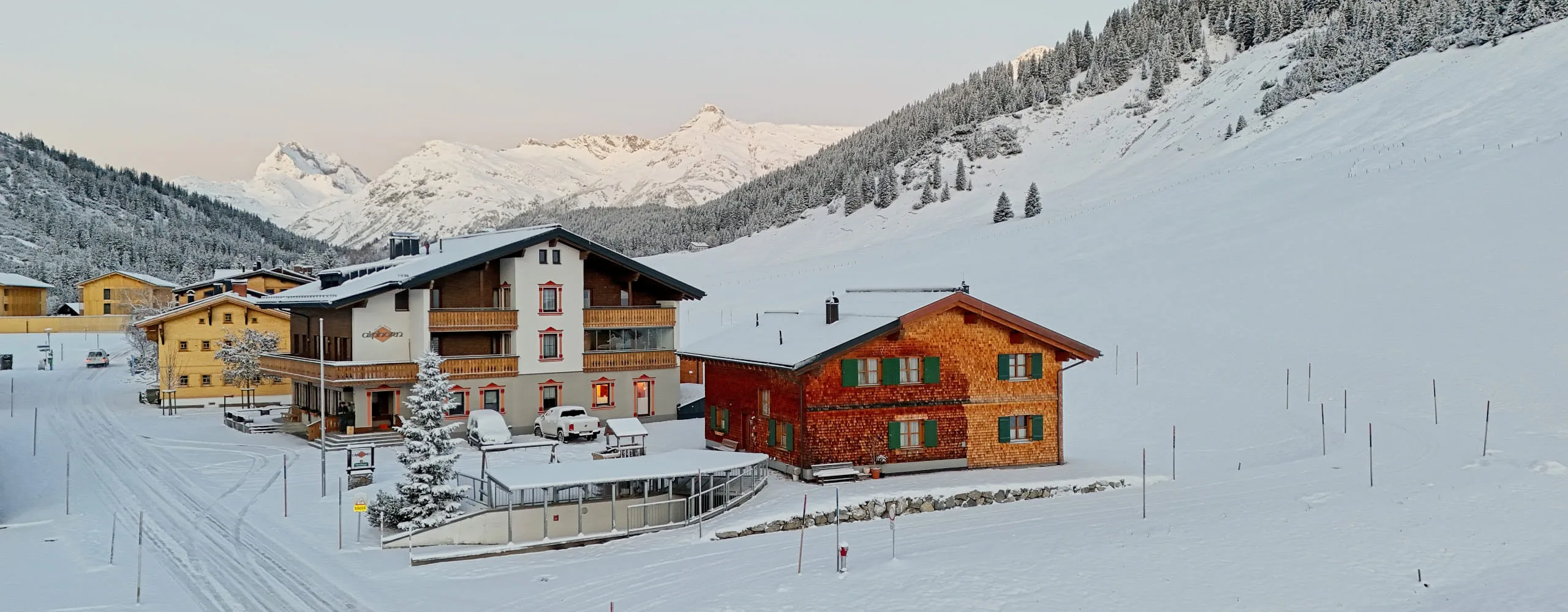 View of Gasthof Alphorn in winter with snow-covered mountains in the background