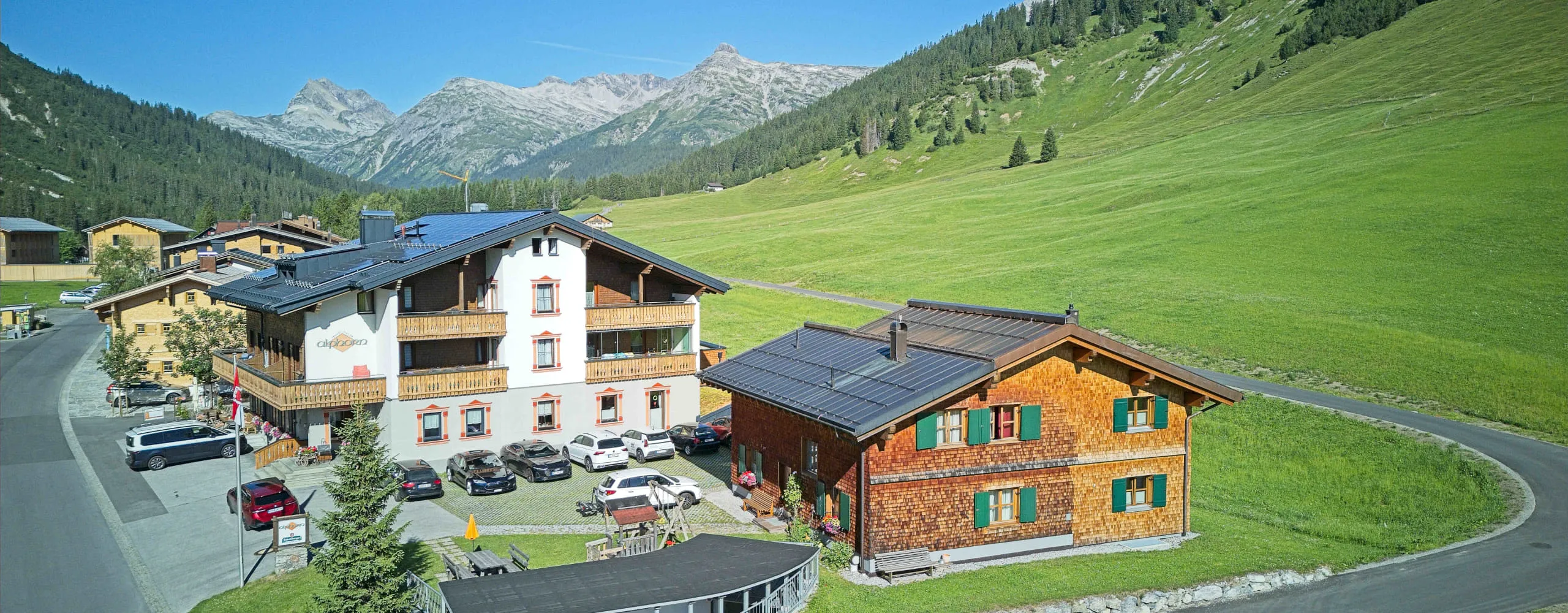 Bergdorf mit Holzhäusern und grüner Landschaft