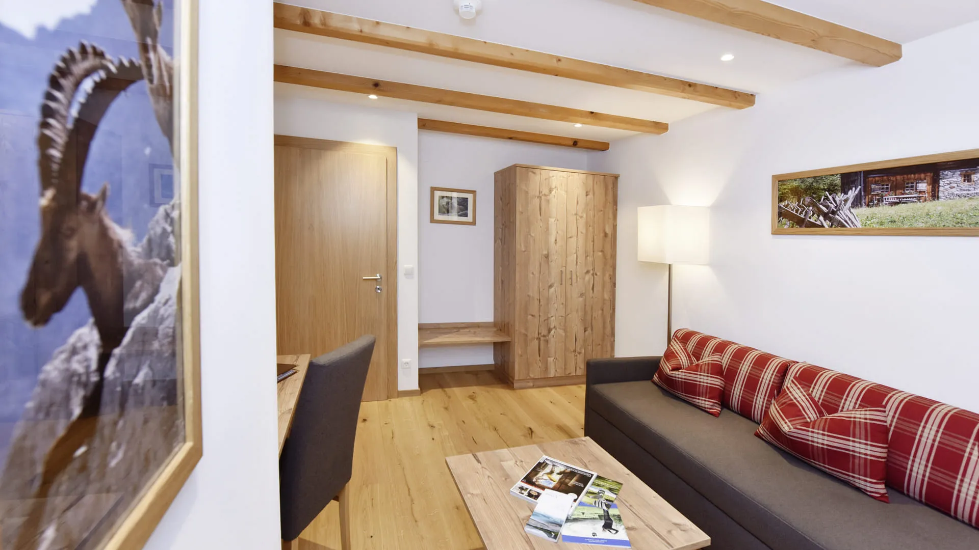 Living area with wood details, couch, table, and opposite door.
