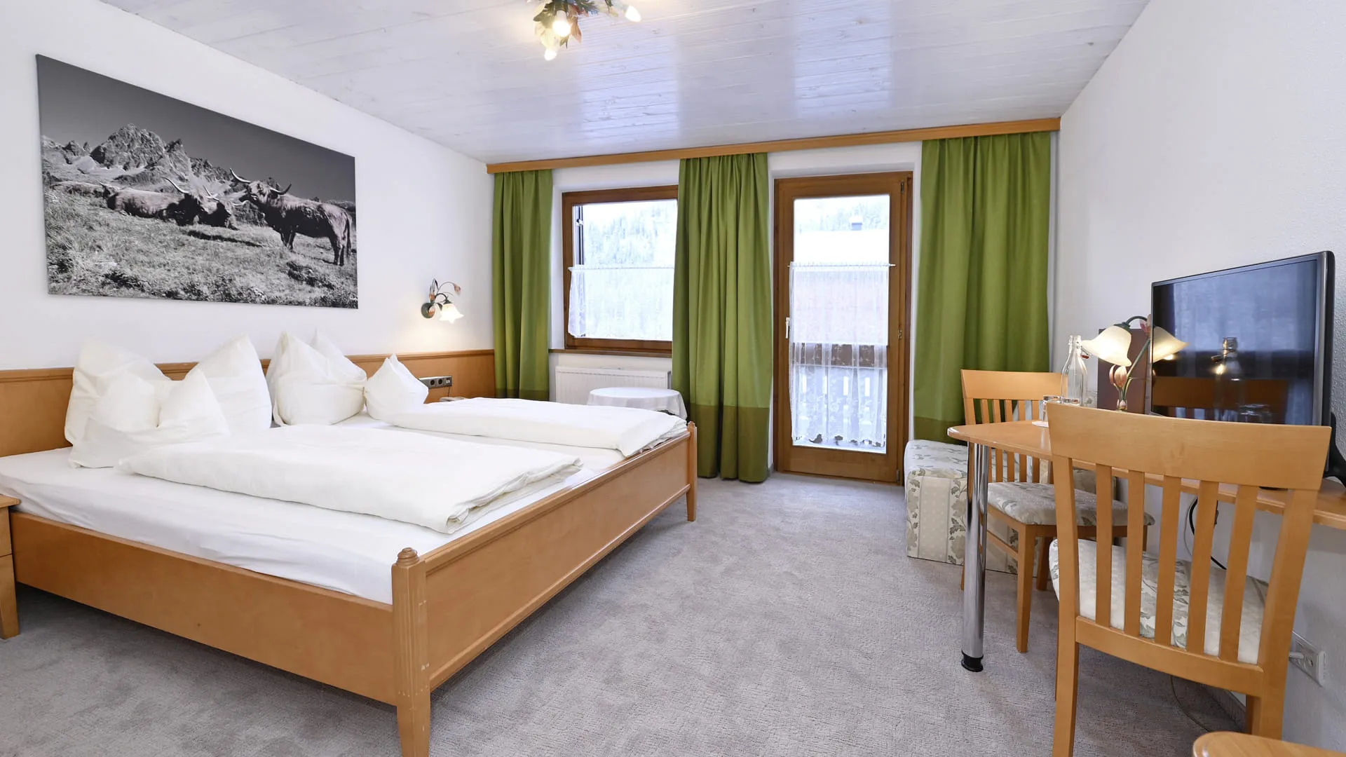 Cozy hotel room with double bed, desk, and curtains