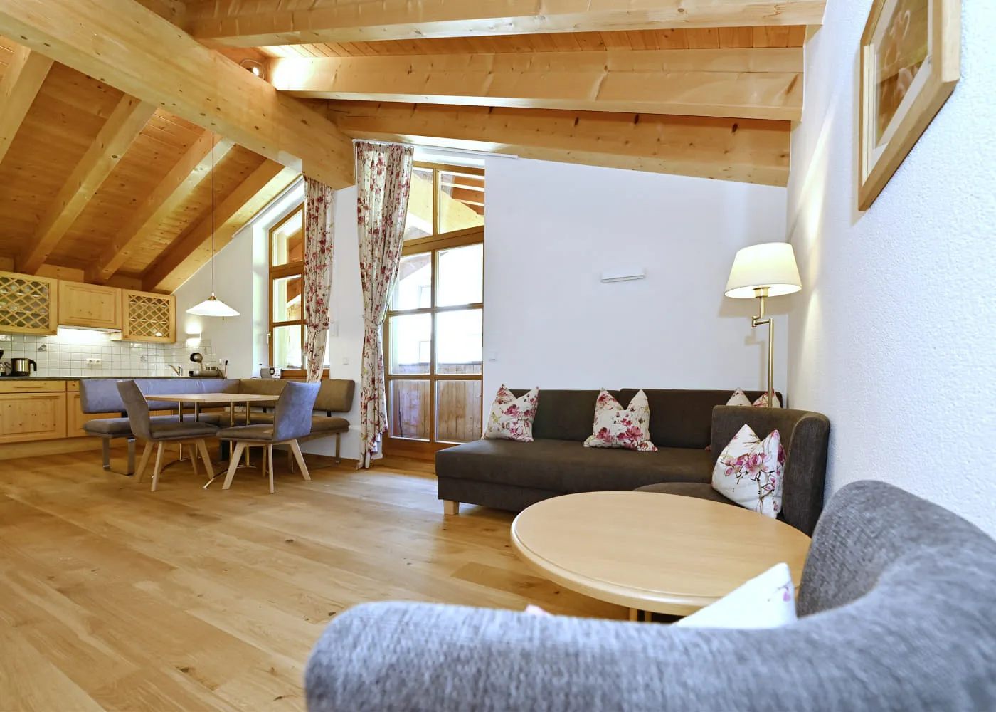 Helle Wohnküche mit Holzverkleidung, Esstisch und gemütlichem Sofa