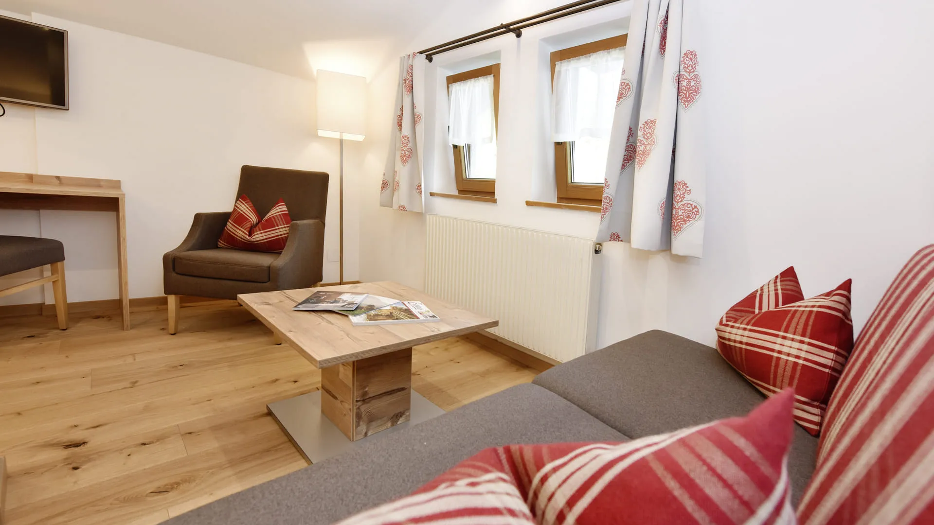 gemütlicher Wohnbereich mit Sofa, Couchtisch und Schreibtisch