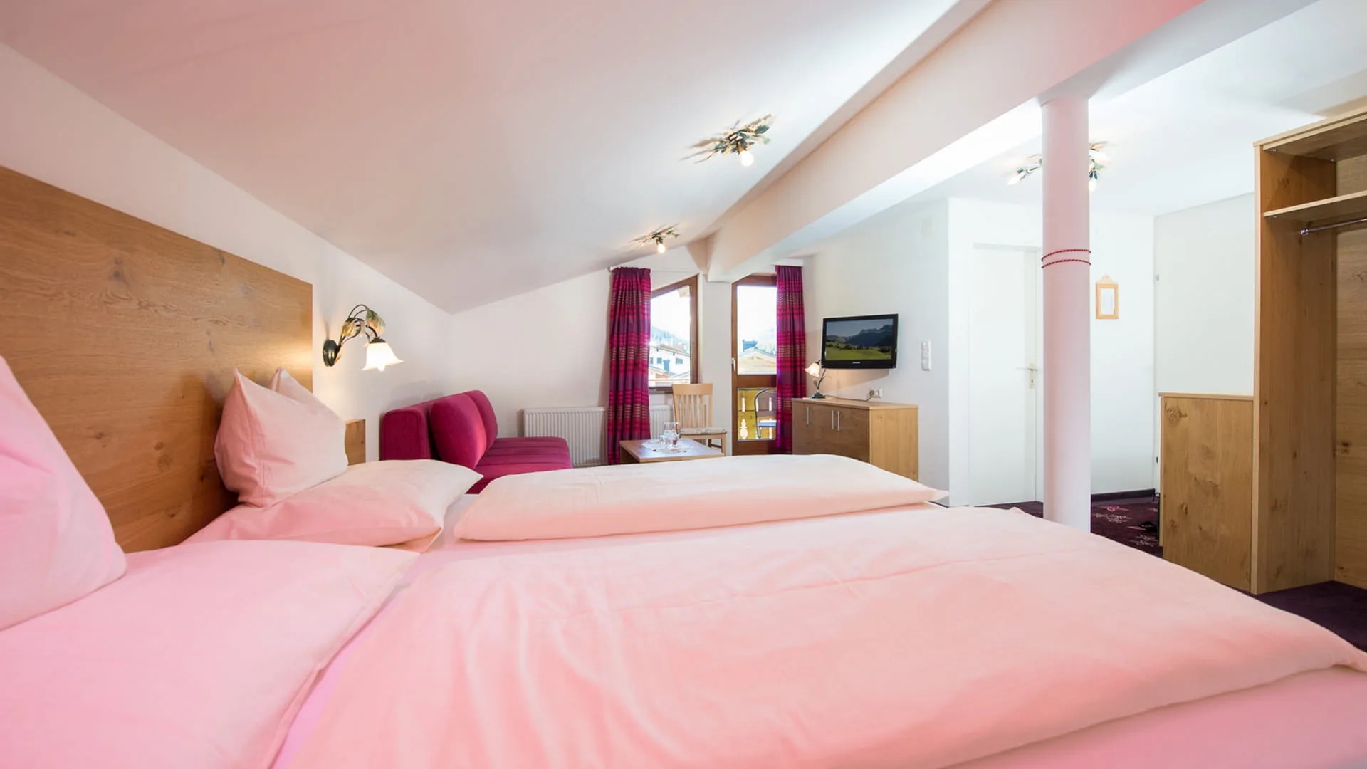 Helle Hotelzimmer mit zwei Betten und gemütlicher Einrichtung.