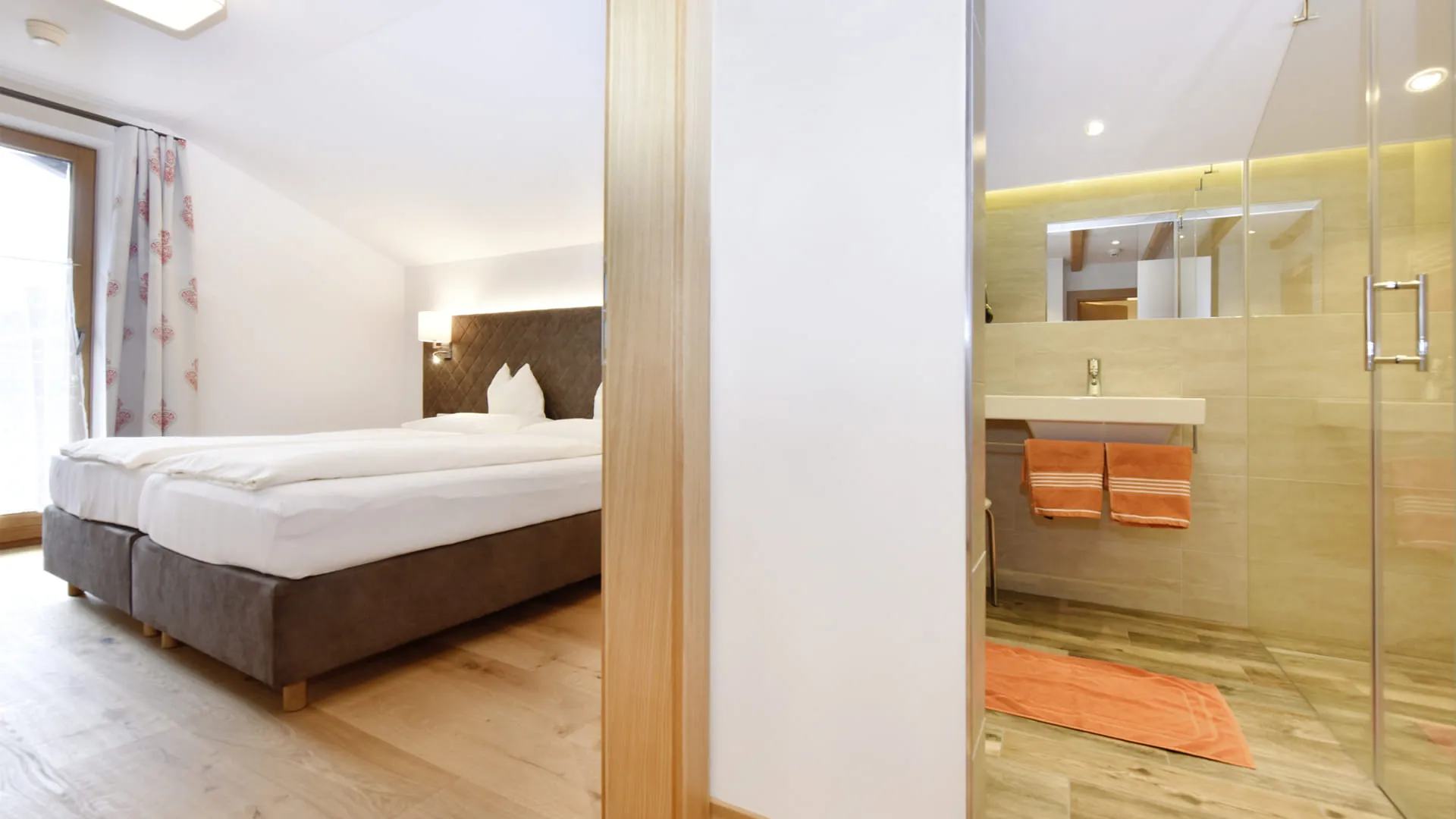 Ein modernes Schlafzimmer mit einem Doppelbett und einem angrenzenden Badezimmer