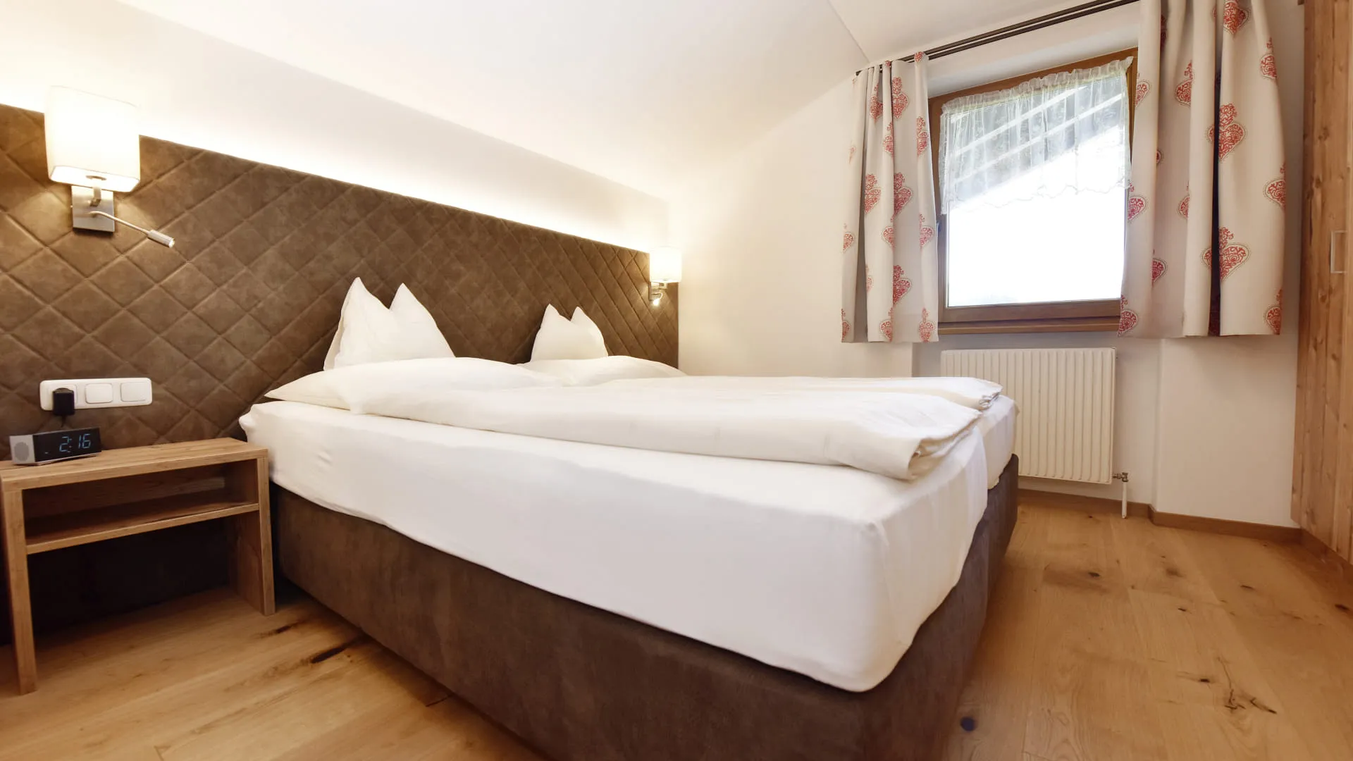 Helles Schlafzimmer mit Doppelbett, Nachttisch und Fenster