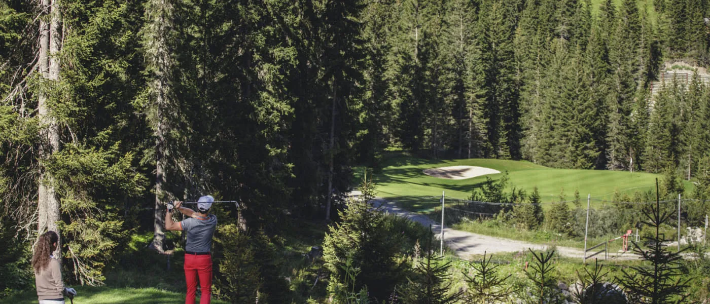 Golfer auf dem Platz in Lech Zürs, umgeben von Bäumen