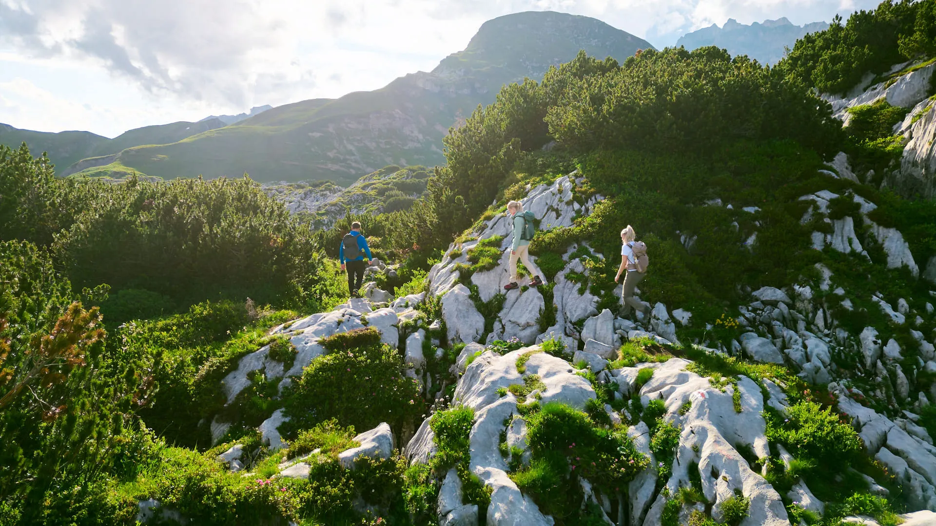 Wanderer auf grünen Felsen in der Lechschleife
