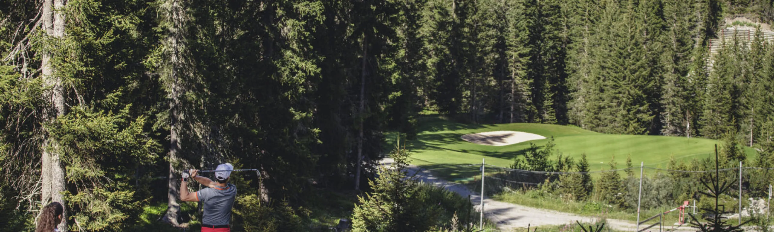 Golfer auf einem Platz in Lech Zürs, umgeben von Bäumen
