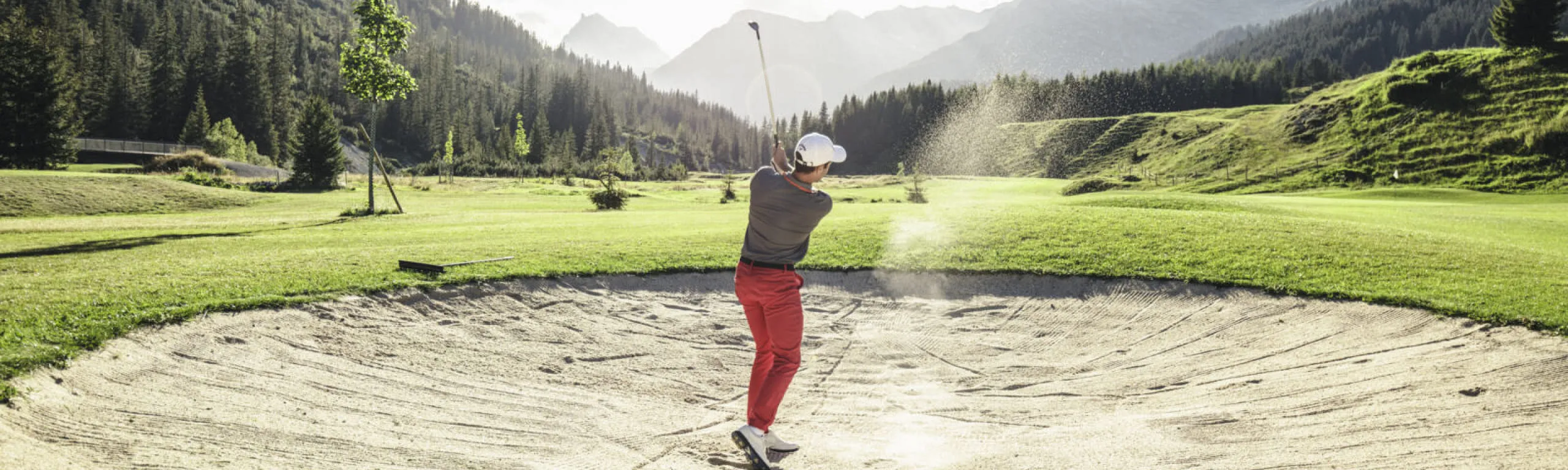 Golfer schlägt aus einem Bunker in Lech Zürs.