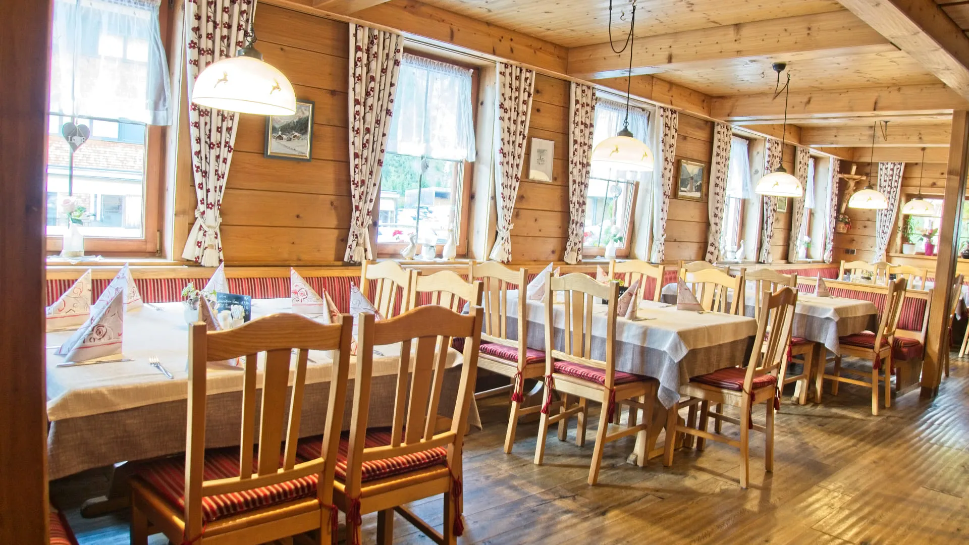 Gemütlicher Essbereich mit Holztischen und Stühlen in einem rustikalen Restaurant