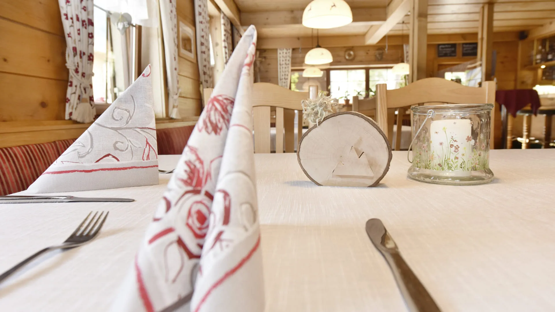 Tischtuch mit dekorativen Servietten und Kerze in einem Holzrestaurant