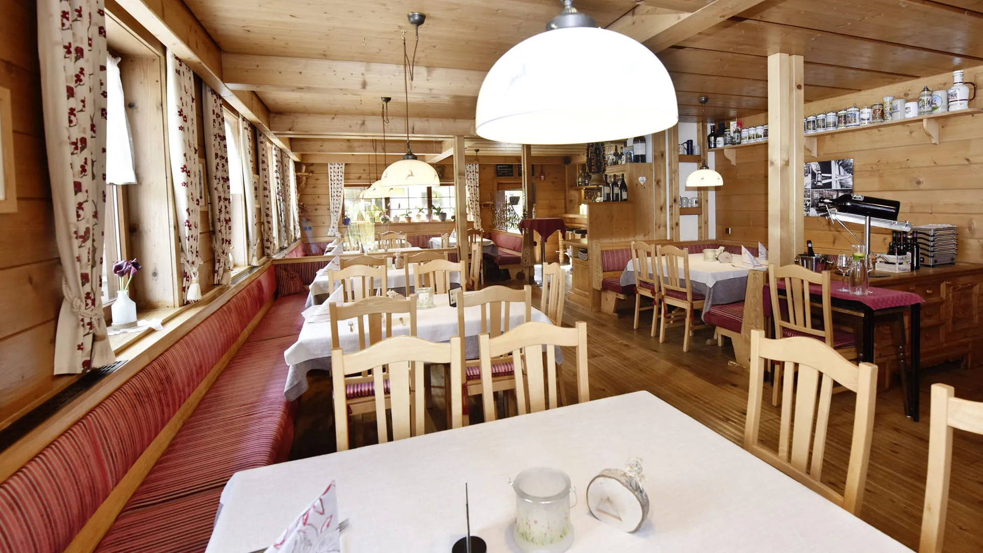 Holzvertäfeltes Restaurant mit Tischen und Stühlen, gemütlicher Atmosphäre.