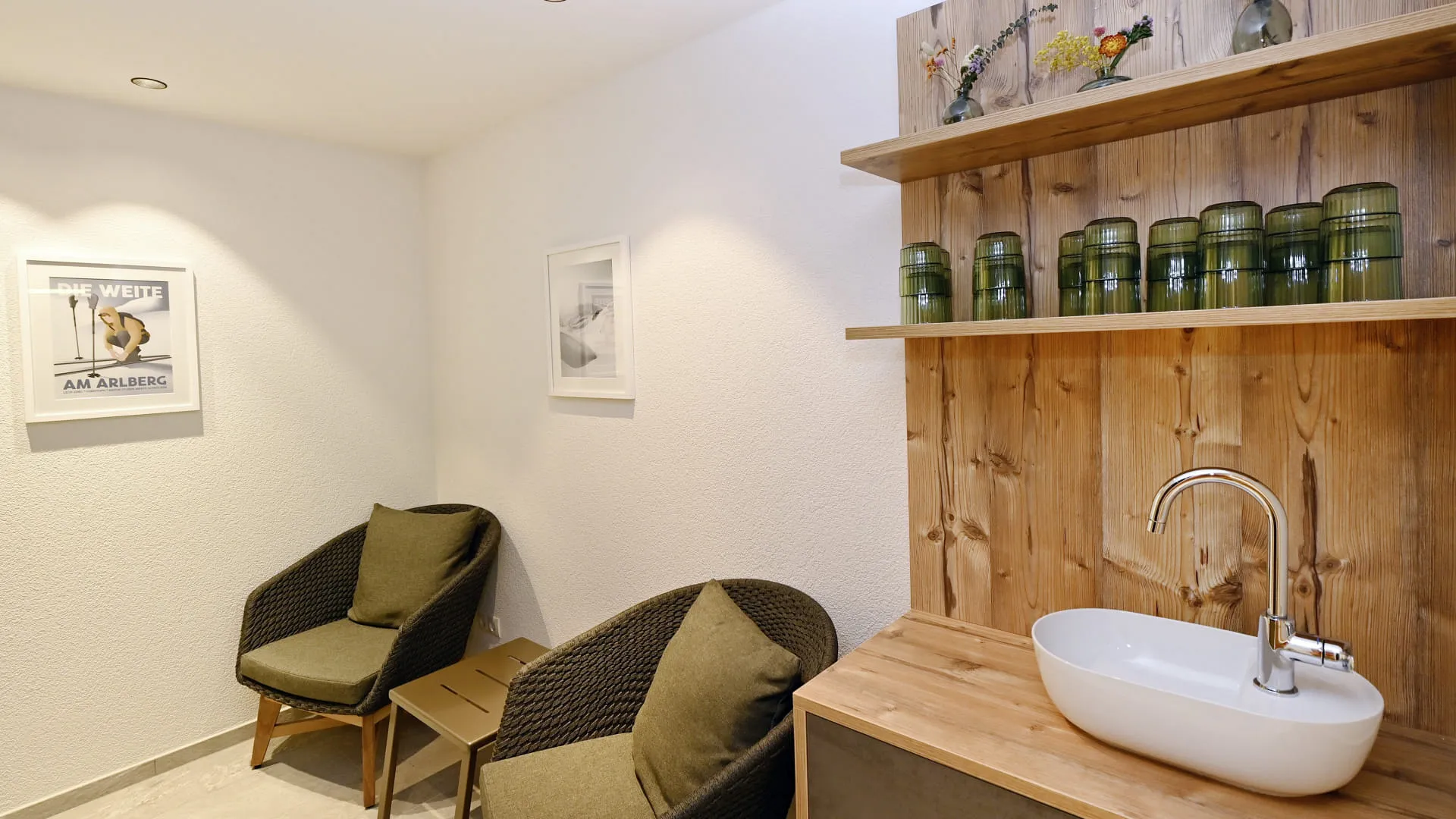 Gemütlicher Raum mit Stuhl, Holzregal und Waschbecken.