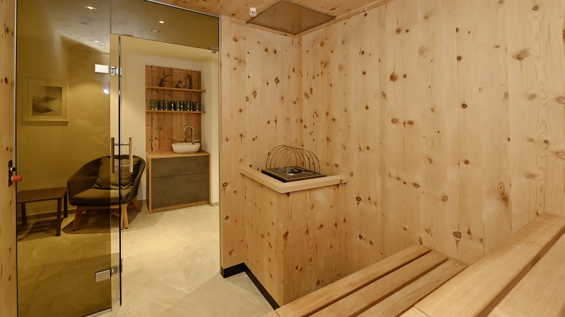 Sauna mit Holzverkleidung, Glasdoor und bequemen Sitzgelegenheiten